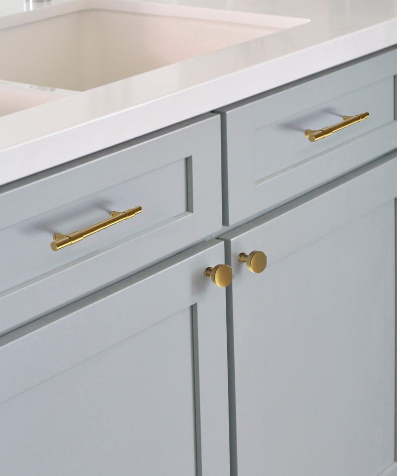 Lavish Riverdale Brass Handle and Knob Mounted on Light Blue Kitchen Cabinet