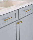 Lavish Riverdale Brass Handle and Knob Mounted on Light Blue Kitchen Cabinet